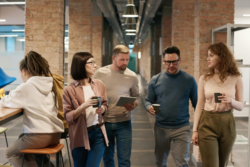 pexels-photo-3182787-3182787 A diverse group of colleagues discussing a project in a modern office hallway.